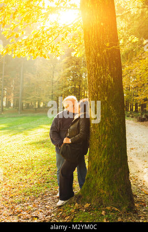 Senior couple kissing and enjoying time at the park at the sunset. Concerpt Family Stock Photo