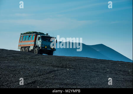 Russian truck drives through the lava sand field of the  Tolbachik volcano, Kamchatka, Russia Stock Photo