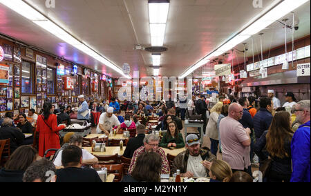 Customers and servers wait staff in the busy, crowded dining room at Katz's Delicatessen, a famous New York City casual restaurant. Stock Photo