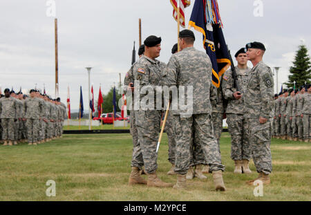 Col. Brian Reed, commander of the 1st Stryker Brigade Combat Team, 25th Infantry Division, passes the 1st Battalion, 24th Infantry Regiment's colors to Lt. Col. Matthew MacNeilly, signifying the assumption of command of the battalion during a change of command ceremony at Ladd Parade Field here July 2. (U.S. Army Photo By: Sgt. Thomas Duval, 1/25 SBCT Public Affairs) 120702-A-BE343-016 by 1 Stryker Brigade Combat Team Arctic Wolves Stock Photo