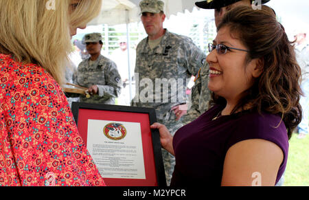 Kirsten Reed, wife of Col. Brian Reed, commander of the 1st Stryker Brigade Combat Team, 25th Infantry Division, presents Cynthia Raugh, wife of Lt. Col. David Raugh,  (outgoing) commander of the 5th Squadron, 1st Cavalry Regiment with the Army Wives Seal prior to a change of command ceremony at Ladd Parade Field Fort Wainwright, Alaska July 2, 2012. (U.S. Army Photo By: Sgt. Thomas Duval, 1/25 SBCT Public Affairs) 120703-A-BE343-003 by 1 Stryker Brigade Combat Team Arctic Wolves Stock Photo