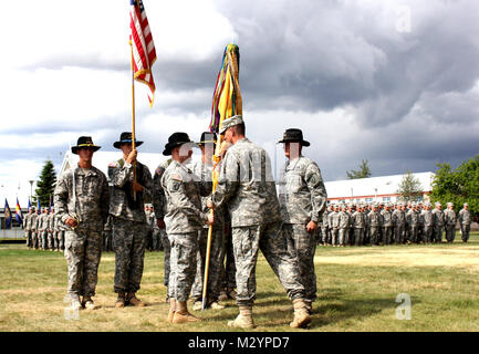 Col. Brian Reed, commander of the 1st Stryker Brigade Combat Team, 25th Infantry Division, passes the 5th Squadron, 1st Cavalry Regiment's colors to Lt. Col. Erik Krivda, signifying the assumption of command for the battalion during a change of command ceremony at Ladd Parade Field Fort Wainwright, Alaska July 2, 2012. (U.S. Army Photo By: Sgt. Thomas Duval, 1/25 SBCT Public Affairs) 120703-A-BE343-012 by 1 Stryker Brigade Combat Team Arctic Wolves Stock Photo