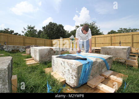 ARLINGTON, Va. -- Ryan Pierce, an architect with the National Park Services’ Historic American Building Survey team, takes detailed measurements on pieces of sandstone columns that once stood at the War Department, August 14, 2012. The columns were moved to Arlington National Cemetery in 1879 and repurposed as gates at the cemetery until 1971 when the cemetery was expanded and the gates were deemed not large enough to allow vehicle traffic through. The gates have been in storage at the cemetery ever since. The cemetery is working with the U.S. Army Corps of Engineers to determine if the column Stock Photo