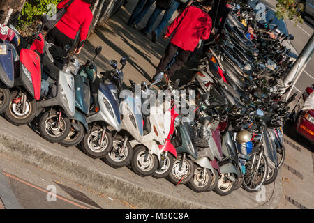 Motorbike, motorcycle scooters parked in row in city street corner, North District, Taichung City, Taiwan Stock Photo