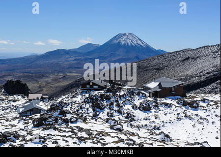 View from Mount Ruapehu on Mount Ngauruhoe with a ski cottage in  the foreground. Unesco world heritage sight Tongariro National Park, North Island, New Zealand Stock Photo