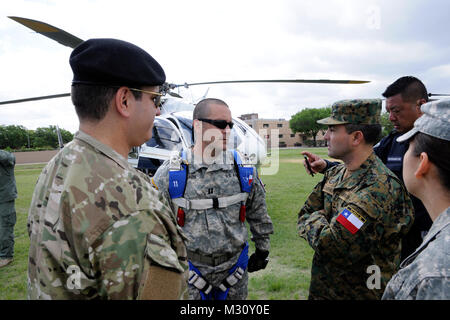 Lt. Col. Rafael Cabrera Osorio (right), and  Lt. Cmdr. Jorge Eduardo Bastias (left), visit with Capt. Dan Edwards (center) during a visit to the Texas Military Forces at Camp Mabry, Austin, Texas, April 20, 2013. Cabrera and Bastias were part of a Chilean Defense Forces Public Affairs delegation that visited and exchanged best practices with their counterparts in the Texas Military Forces. (Texas National Guard photo by Staff Sgt. Malcolm McClendon). Chilean Public Affairs delegation visits Texas Military Forces counterparts by Texas Military Department Stock Photo