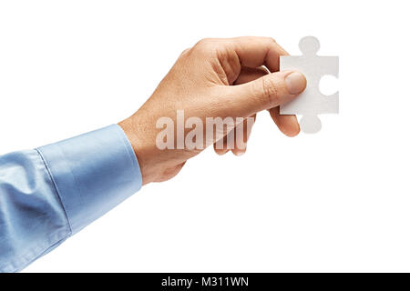 Man holding in hand puzzle element and looks for a solution to