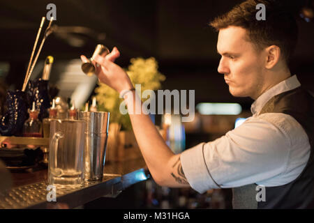 CARDIFF, UK. 24 January 2018. Matthew Jones, aged 28 from Llantrisant mixing a cocktail at the Dead Canary speakeasy in Cardiff. Modelled with a 1920s Stock Photo