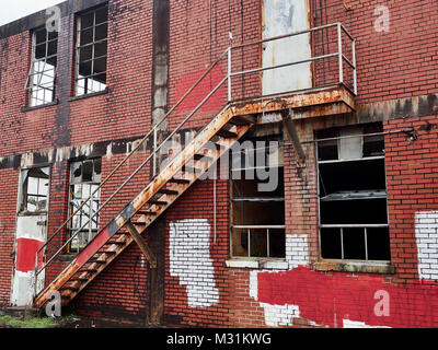 Second floor fire escape exterior of a run down abandoned building that is rusting and part of urban decay in Montgomery Alabama USA. Stock Photo