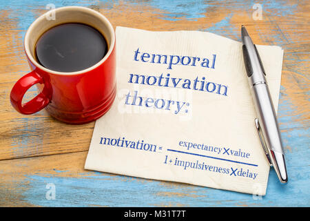 temporal motivation theory, equation - handwriting on a napkin with a cup of coffee Stock Photo