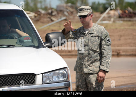 Oklahoma Army National Guardsman, Sgt Derek Fry with Scout/Sniper Platoon, Headquarter Company, First ot the 179th, 45th Infantry Brigade Combat Team, Stillwater Oklahoma, mans an entry control point to a Moore, Oklahoma neighborhood which was devastated on May 20th, 2013 by an F5 tornado. Sgt Fry controlled access to the area and managed traffic flow providing security for private property and assuring rescure and clean up personnel unhindered access.  (U.S. Air National Guard photo by Master Sgt. Mark Moore/Released) Sgt. Derek Fry 002 by Oklahoma National Guard Stock Photo