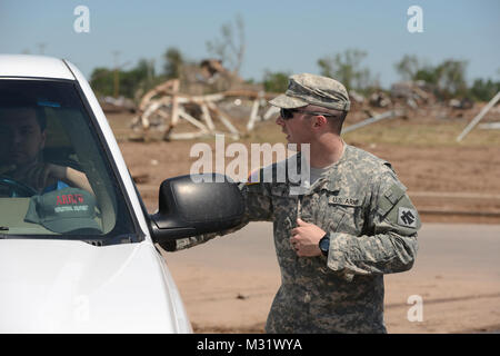 Oklahoma Army National Guardsman, Sgt Derek Fry with Scout/Sniper Platoon, Headquarter Company, First ot the 179th, 45th Infantry Brigade Combat Team, Stillwater Oklahoma, mans an entry control point to a Moore, Oklahoma neighborhood which was devastated on May 20th, 2013 by an F5 tornado. Sgt Fry controlled access to the area and managed traffic flow providing security for private property and assuring rescure and clean up personnel unhindered access.  (U.S. Air National Guard photo by Master Sgt. Mark Moore/Released) Sgt. Derek Fry 003 by Oklahoma National Guard Stock Photo