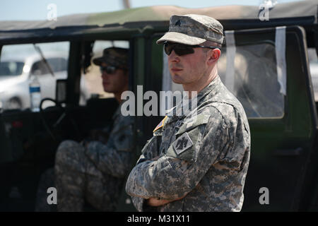 Oklahoma Army National Guardsman, Sgt Derek Fry with Scout/Sniper Platoon, Headquarter Company, First ot the 179th, 45th Infantry Brigade Combat Team, Stillwater Oklahoma, mans an entry control point to a Moore, Oklahoma neighborhood which was devastated on May 20th, 2013 by an F5 tornado. Sgt Fry controlled access to the area and managed traffic flow providing security for private property and assuring rescure and clean up personnel unhindered access.  (U.S. Air National Guard photo by Master Sgt. Mark Moore/Released) Sgt. Derek Fry 005 by Oklahoma National Guard Stock Photo