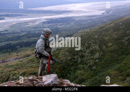 Capt. Mike Nolan, commander of Headquarters and Headquarters Company, 3rd Battalion, 21st Infantry Regiment, 1st Stryker Brigade Combat Team, 25th Infantry Division, looks down into the ravine of the high angle range at the Northern Warfare Training Center in Black Rapids, Alaska Sept. 3. (U.S. Army photo by Sgt. Michael Blalack, 1/25 SBCT Public Affairs) 130903-A-AX238-014 by 1 Stryker Brigade Combat Team Arctic Wolves Stock Photo