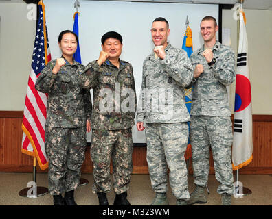 Republic of Korea air force Capt. Yoo Jin Kyoung, Military Police Squadron operations officer, ROKAF Lt. Col. Gyu Hwan Lee, MPS commander, Lt. Col. Jason Beck, 51st Security Forces Squadron commander, and Capt. Joseph Schneider, 51st SFS operations officer, celebrate the signing of the Air Force and ROKAF Agreement for Base Security and Law Enforcement on Osan Air Base, ROK, Sept. 25, 2013. Safeguarding equipment and protecting and serving base personnel and their families are top priorities for both squadrons. (U.S. Air Force photo/Airman 1st Class Ashley J. Thum) 51st SFS, ROKAF sign securit Stock Photo