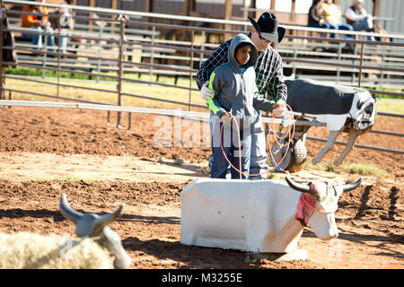 Rick Crider of Ponder, Texas, instructs Isaac Carlson from Lawton, Okla., on how to throw at the roping station, one of five instructional courses, set up during the Horseback Heroes event on October 19, 2013.  Isacc is the son of Chief Warrant Officer 3 Ben and Eleanor Carlson, Oklahoma Army Nationsl Guard.  Horseback Heroes is an annual event to provide the opportunity for children of Oklahoma National Guardsmen to gain hands-on experience in the daily caretaking of horses.  This year's event took place at Covey Creek Cattle Co. in Oklahoma City, Okla.  (Photo by 1st Lt. Christopher Leblo, O Stock Photo