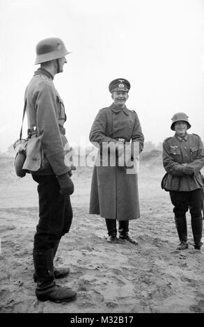 A German officer and two soldiers have a smile, ca. 1938. Stock Photo