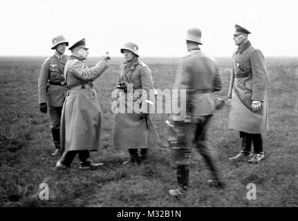 A German officer appears to berate a soldier in the field during WWII, ca. 1938. Stock Photo