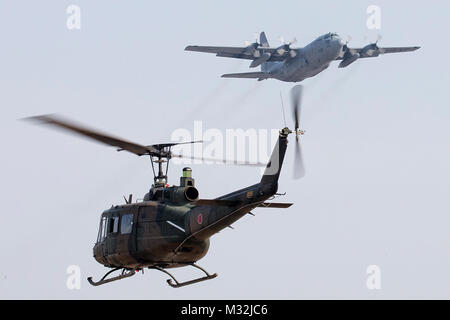 A Japan Ground Self-Defense Force UH-1J Iroquois and a U.S. Air Force C-130H Hercules fly over Yokota Air Base, Japan, March 8, 2016. The JGSDF UH-1J is assigned to the Eastern Helicopter, 1st Aviation and the USAF C-130H is assigned to the 36th Airlift Squadron. (U.S, Air Force photo by Osakabe Yasuo/Released) Japanese UH-1J Iroquois and US C-130H Hercules Operating Over Yokota Air Base by #PACOM Stock Photo