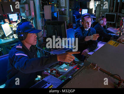 WATERS NEAR GUAM (Mar. 9, 2016) Lt. Thomas Brewer, (right), Chief Engineer of Arliegh Burke-class guided-missile destr160309-N-DJ750-318 WATERS NEAR GUAM (Mar. 9, 2016) Lt. Thomas Brewer, (right), Chief Engineer of Arliegh Burke-class guided-missile destroyer USS McCampbell (DDG 85), and Japan Maritime Self-Defense Force (JMSDF) Lt. Cmdr. Hironori Ikeda, of JMSDF Chief staff, Escort Division 6, discuss tactical data from the Combat Information Center (CIC) during Multi Sail 2016. Multi Sail is a bilateral training exercise aimed at interoperability between the U.S. and Japanese forces. This ex Stock Photo