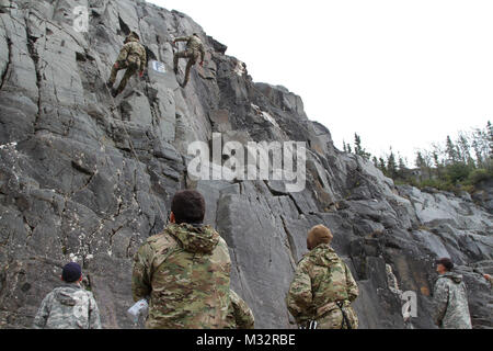 Sgt. William Travis (far left) and Sgt. 1st Class Adam McQuiston (far right), instructors at the Northern Warfare Training Center Black Rapids, Alaska, encourage Rangers as they descend a cliff face August 27, 2014. Rangers from A Co., 3rd Battalion, 75th Rangers gained valuable skills during a five-day course at NWTC designed by the instructors to benefit the Rangers as the Army transitions its focus from Afghanistan to the Pacific Theater of Operations. (U.S. Army photo by Spc. Corey Confer, 1/25 SBCT Public Affairs, Fort Wainwright, Alaska) IMG 7070 by 1 Stryker Brigade Combat Team Arctic W Stock Photo