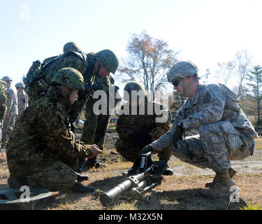 Sgt. 1st Class Jesse Queck, a platoon sergeant with Headquarters and Headquarters Company Mortar Platoon, 1st Battalion, 17th Infantry Regiment, 2nd Stryker Brigade Combat Team, 2nd Infantry Division from Joint Base Lewis-McChord, Wash. introduced the 60mm mortar system (M224A1) to Japan Ground Self-Defense Force members here, Oct. 23.The demonstration was part of Orient Shield 14, an annual bilateral training exercise, which brings the two forces together to share military experiences, tactics and practices.  The exercise takes place Oct. 27 – Nov. 7. US Army and JGSDF Train on 60mm Mortars b Stock Photo