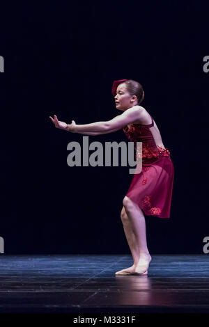 Twelve year old girl performing a solo lyrical dance onstage, conveying sadness and guilt Stock Photo