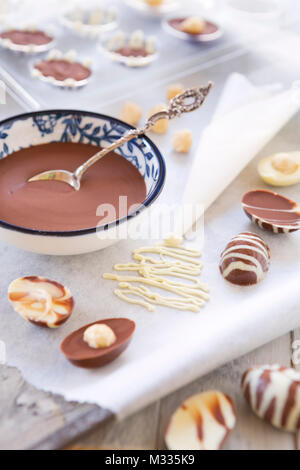 Homemade milk and white chocolate Easter eggs on a rustic table. Stock Photo