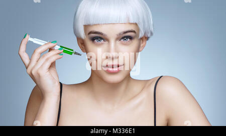 Beautiful woman receiving botox injection in cheek. Portrait of woman getting beauty facial injections. Clean Beauty concept Stock Photo