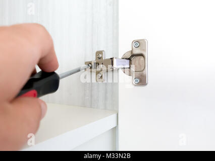 Repairman install cabinet hinge Stock Photo