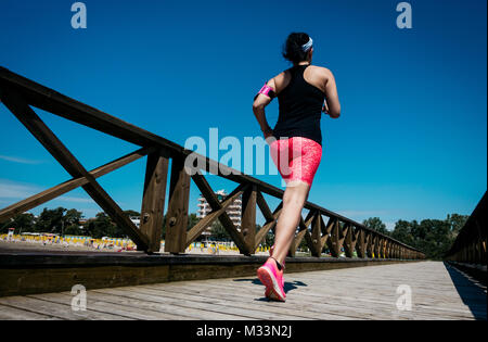 Young woman jogging cross-country running in summer seaside.  Concept fitness and healthy lifestyle Stock Photo