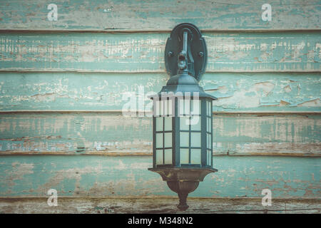 Close up old vintage wall lamp on wooden wall in vintage style. Stock Photo