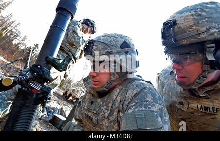 Spc. Dominic Suriano, center, and Army Sgt. Stephen Lawler, both assigned to the 1st Battalion (Airborne), 501st Infantry Regiment, 4th Infantry Brigade Combat Team (Airborne), 25th Infantry Division, U.S. Army Alaska, prepare to fire a 81 mm mortar on Joint Base Elmendorf-Richardson, Alaska, Friday, April 3, 2015. The indirect-fire infantrymen directed accurate mortar fire on simulated hostile targets under stressed conditions testing reaction times, and their mastery with the crew-served weapons. (U.S. Air Force photo/Justin Connaher) 25th Infantry Division Soldiers direct mortar fire on sim Stock Photo