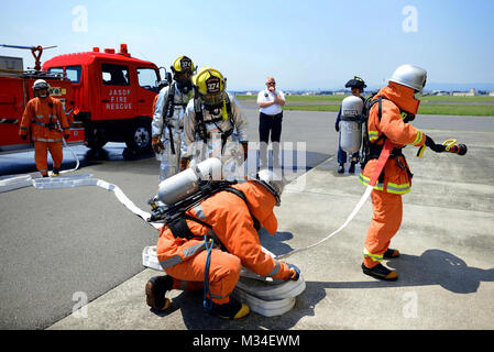 Firefighters from the 374th Civil Engineer Squadron and Japan Air Self-Defense Force prepare to enter a fire training facility May 26, 2015, at Yokota Air Base, Japan. This bilateral training opportunity ensured that the 374 CES and JASDF firemen are able to work in sync with one another if they should have to emergencies on base. (U.S. Air Force photo by Airman 1st Class Delano Scott/Released) US, Japanese Military Firefighters Train in Japan by #PACOM Stock Photo
