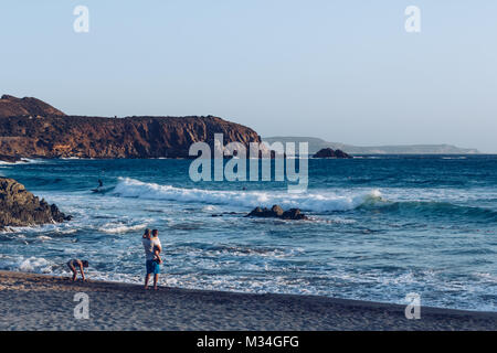 Family looking surfer at the beach of Masua near the Pan di Zucchero at the west coast of Sardinia. Italy. Stock Photo