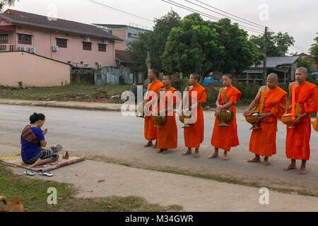 Vang Vieng, Laos - January 21, 2017: Buddhist monks collecting alms in the morning in Vang Vieng, Laos Stock Photo