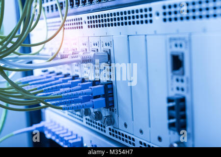 Fiber cables connected to optic ports and UTP, Network cables connected to ethernet ports. Stock Photo