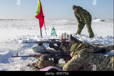 Yavoriv, Ukraine – U.S., Canadian, Ukrainian, and Lithuanian service members conduct marksmanship training at the Yavoriv Combat Training Center here Feb. 6. Currently more than 220 New York Army National Guard Soldiers are deployed to Ukraine working hand in hand with the Ukrainian Army as they strive toward their goal of attaining NATO interoperability. (U.S. Army photo by Sgt. Alexander Rector) Stock Photo