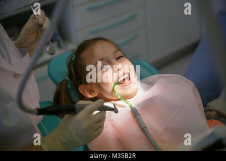 Little girl at dentist office, getting ready for a caries treatment. Prevention, pediatric medical care concept. Stock Photo