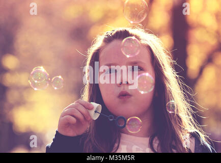 Little girl making soap bubbles Stock Photo