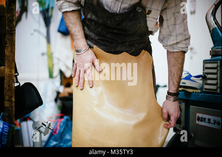 interior repair shop and shoe making, shoemaker spreads leather close-up view Stock Photo