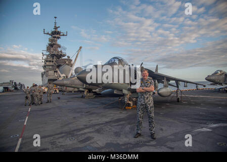 170723-N-YG104-093 CORAL SEA (July 23, 2017) Royal Australian Navy Capt. Guy Holthouse, sea combat commander for the Talisman Saber Combined Amphibious Force, poses with an AV-8B Harrier on the flight deck of the amphibious assault ship USS Bonhomme Richard (LHD 6) during Talisman Saber 17. Talisman Saber is a biennial U.S.-Australia bilateral exercise held off the coast of Australia meant to achieve interoperability and strengthen the U.S.-Australia alliance. (U.S. Navy photo by Mass Communication Specialist 2nd Class Sarah Villegas/Released) Century-Strong U.S.-Australian Partnership Further Stock Photo