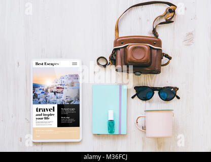 overhead travel agency website on tablet screen  with essential vacation items Stock Photo