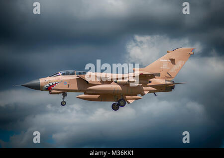 RAF Tornado in desert camouflage landing against grey sky, Farnborough air show.