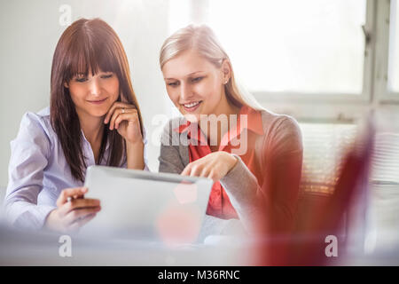 Young businesswomen using tablet computer in office Stock Photo