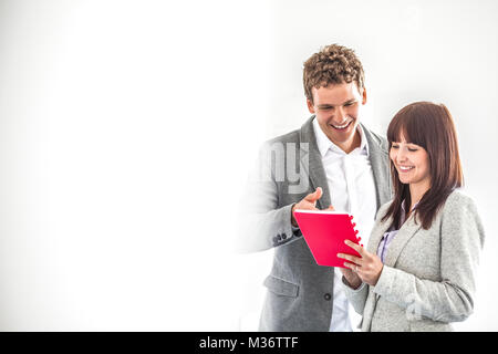Smiling young business people discussing over note pad in office Stock Photo