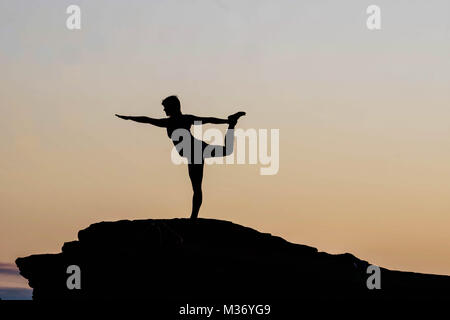female doing yoga at sunrise at Horseshoe Bend on a rock Stock Photo