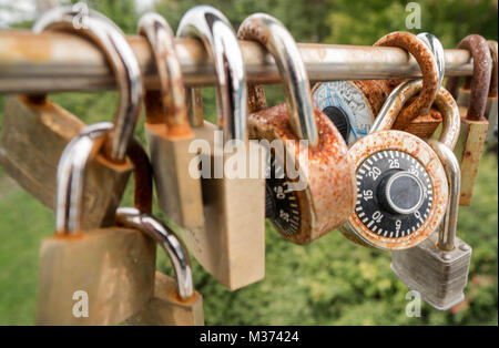 many padlocks and locks in different shapes and sizes locked onto a bridge railing in Montreal and symbolizing eternal love and friendship forever Stock Photo