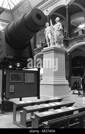 08-15-1981 Prussia exhibition in Berlin 1981. View of part of the exhibition in the Lichthof at Martin-Gropius-Bau in Berlin. Prussian symbols. On the left a cannon of the type 'Fat Bertha', in front of it school desks. In the background on the right a cast of the goddess of victory from the Castle Bridge. | usage worldwide Stock Photo