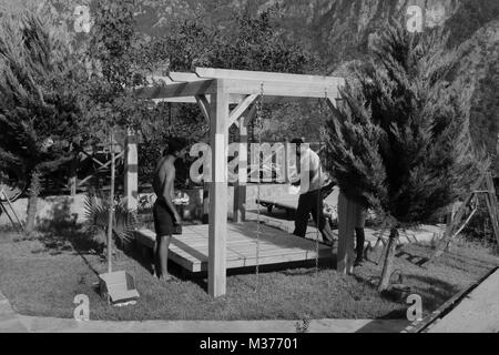 20TH JULY 2017, KABAK,TURKEY: Turkish workmen building a swing seat pergola in an olive garden at kabak, turkey, 20th july 2017 Stock Photo